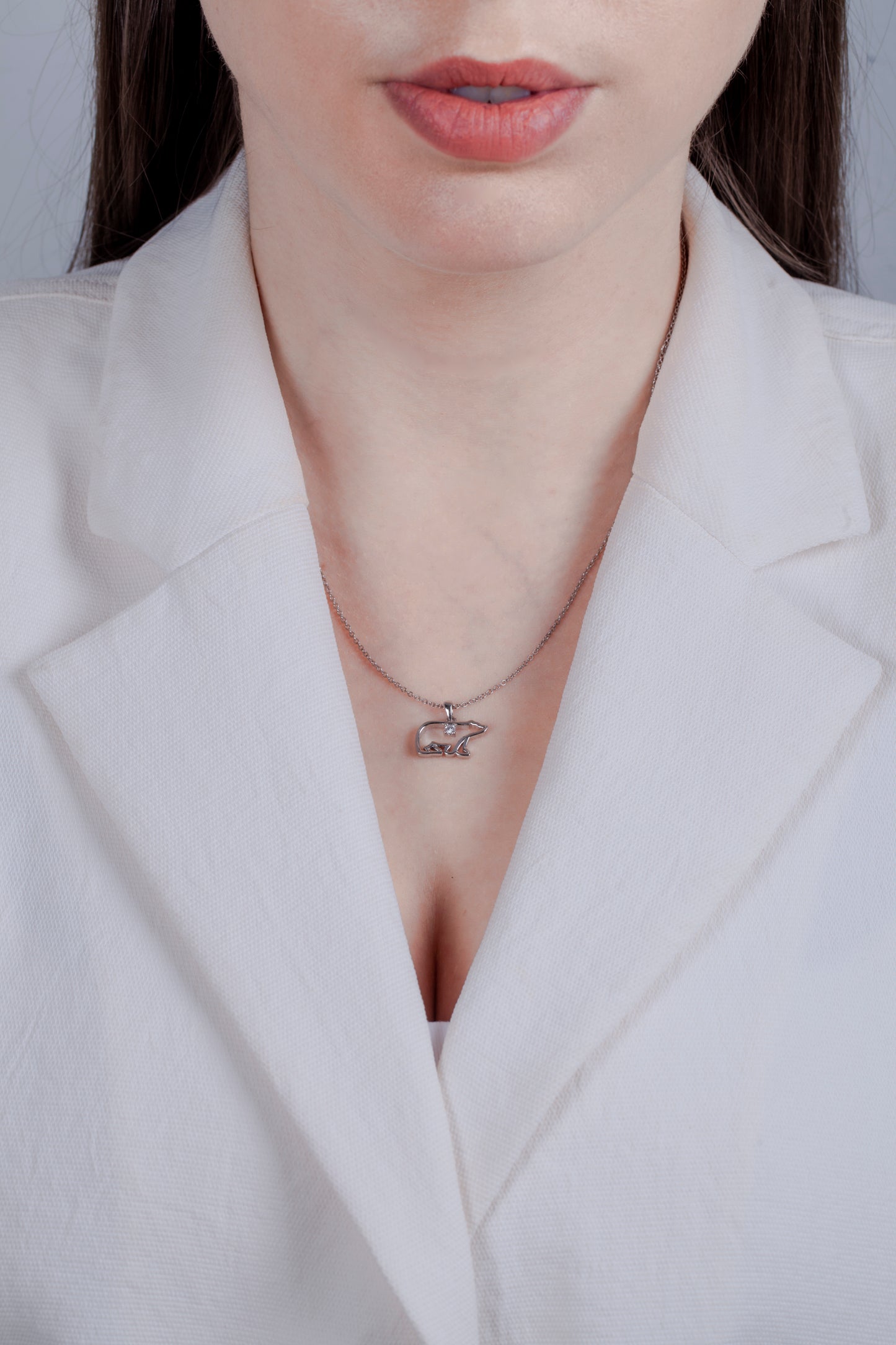 model wearing a Sterling silver Polar Bear pendant featuring a round brilliant cut, canadian diamond.