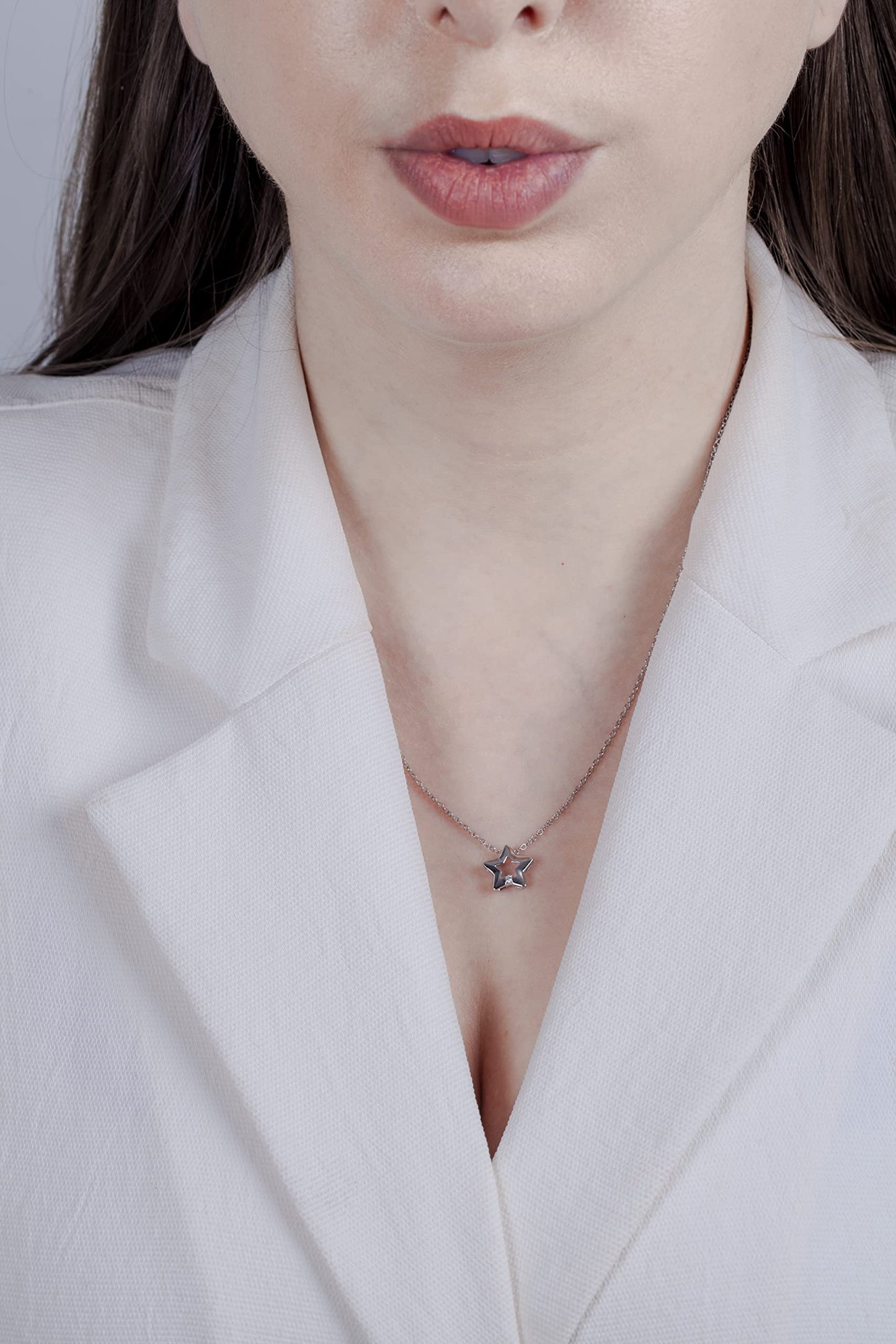 model wearing a Sterling silver star pendant featuring a round brilliant cut, canadian diamond.