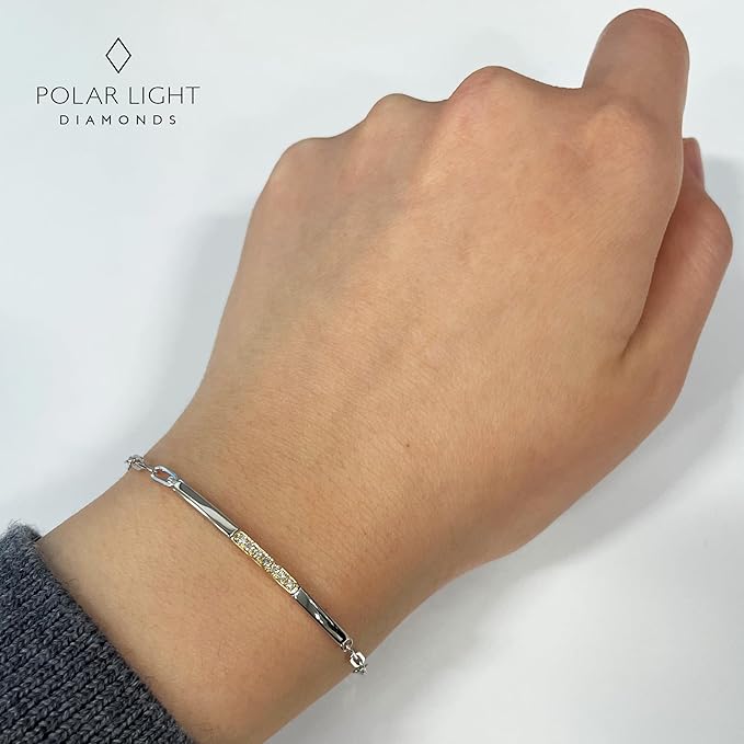 Model wearing a two-tone 10K yellow gold and 925 sterling silver paperclip bracelet on the wrist. Featuring 0.09 carat total weight of natural Canadian diamonds, this high-polish piece offers a minimalistic look suitable for everyday wear.
