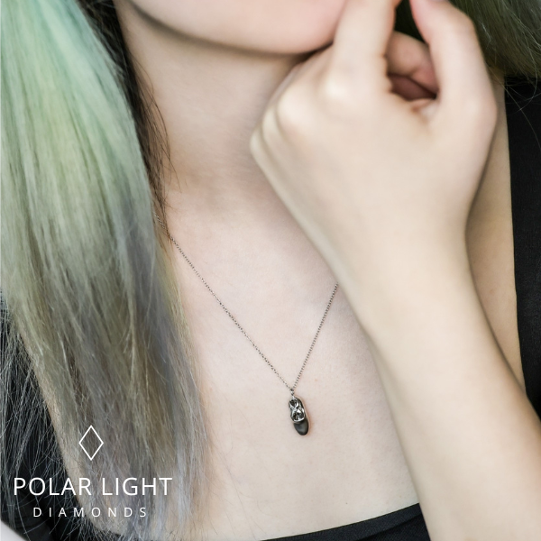 Model wearing a high-polish sterling silver ballet slipper pendant necklace, featuring an intricate cut-out design on a delicate cable chain, with the Polar Light Diamonds brand logo.