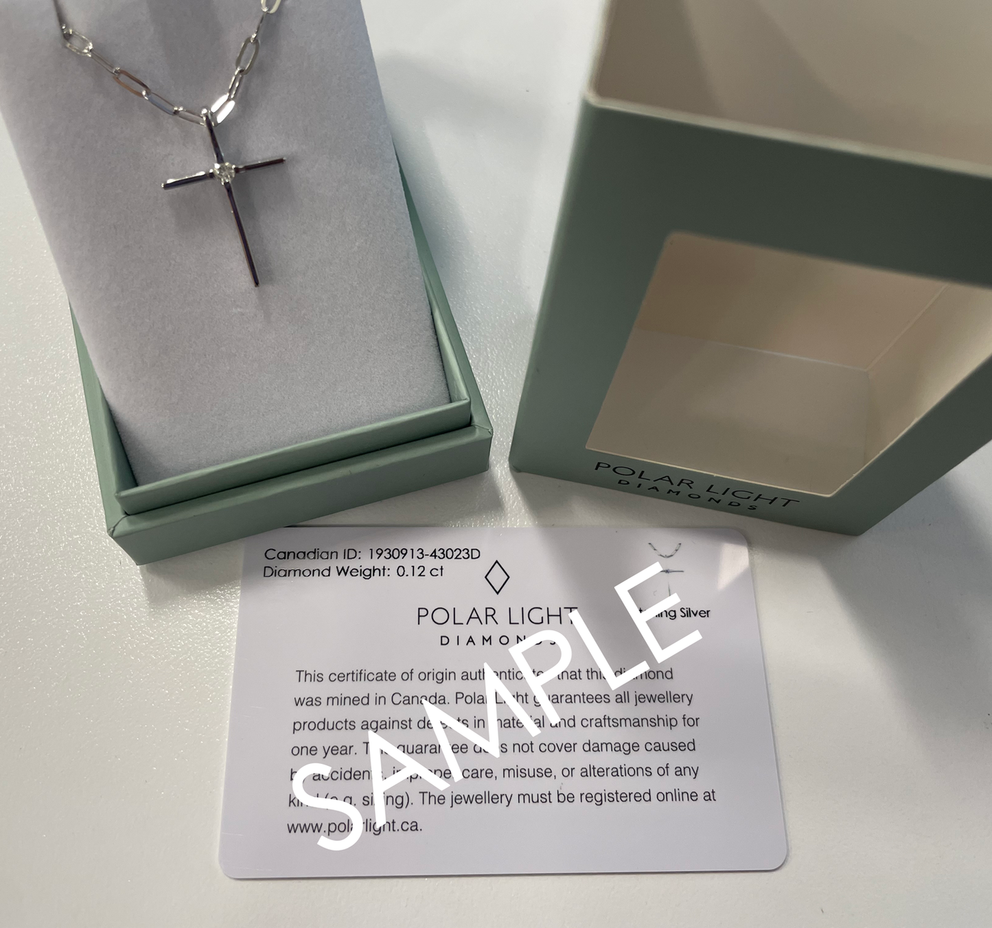 Sterling silver Canadian diamond cross necklace with paperclip chain in a Polar Light Diamonds box with Canadian Diamond ID certificate a on a white background