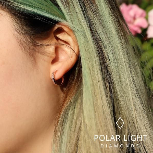 Close-up lifestyle view of a model wearing 10K rose gold channel-set hoop earrings. The design features alternating natural pink sapphires and sparkling Canadian diamonds. The 'Polar Light Diamonds' logo is featured, emphasizing the premium craftsmanship and Canadian heritage of the brand.