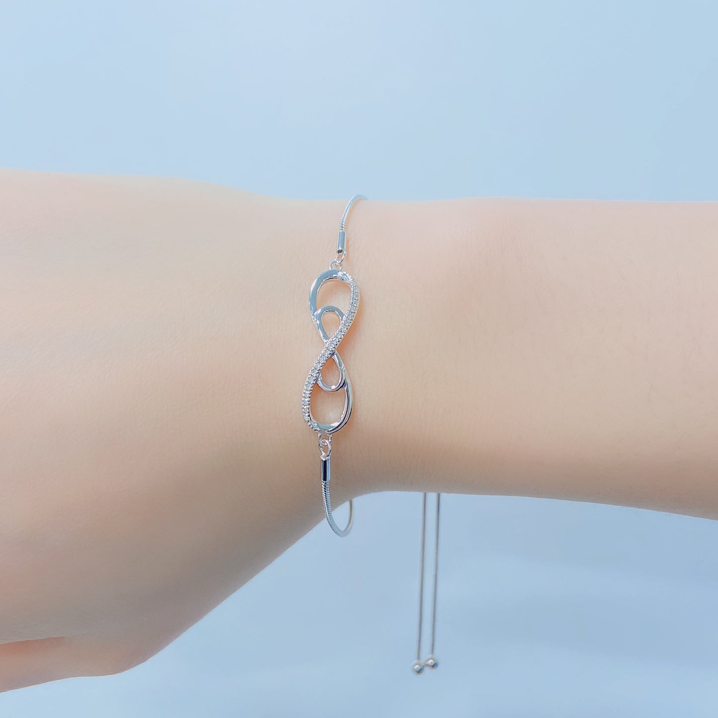 925 sterling silver bolo chain bracelet with a double infinity diamond design. Lifestyle shot on a wrist showing the sparkle of Canadian diamonds and the adjustable silver chain.