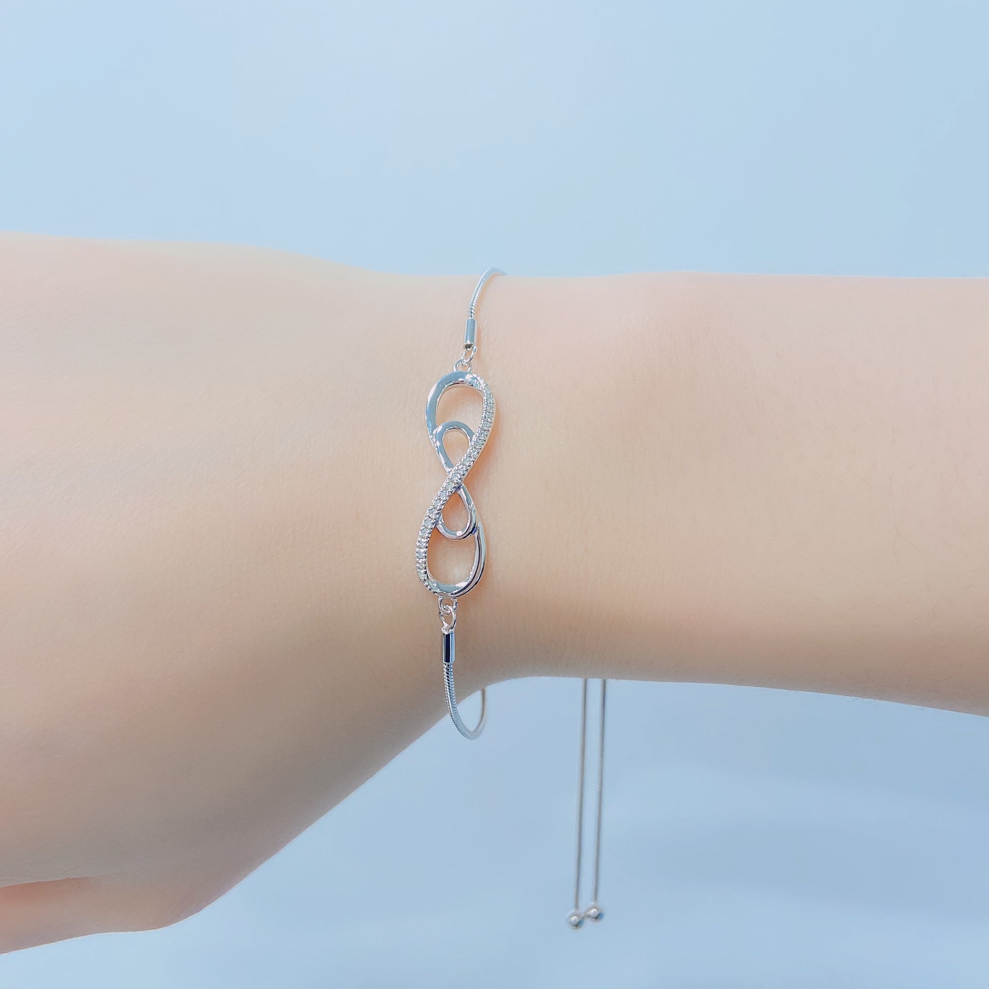 925 sterling silver bolo chain bracelet with a double infinity diamond design. Lifestyle shot on a wrist showing the sparkle of Canadian diamonds and the adjustable silver chain.