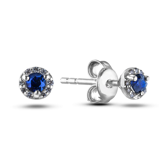 Silver earrings with blue sapphires and surrounding canadian diamonds halo style on a white background , butterfly backing