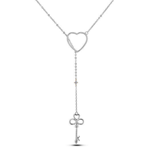 A 925 sterling silver Y-style/Lariat drop necklace on a white background. The chain passes through a polished open-heart slider, dropping down to a dainty Canadian diamond accent in a 10K yellow gold setting, and ending with an intricate key pendant featuring a heart bow and infinity symbol stem.