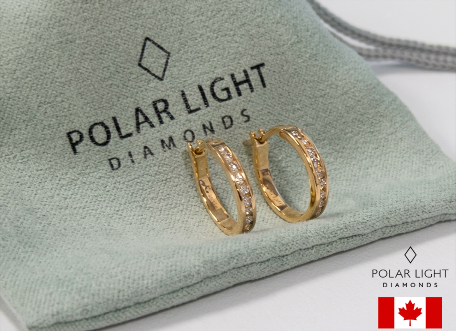 Close-up of 10K Yellow Gold 1/5 Cttw Diamond 1.4cm petite channel-set hoop earrings resting on a green fabric pouch with Polar Light Diamonds branding.