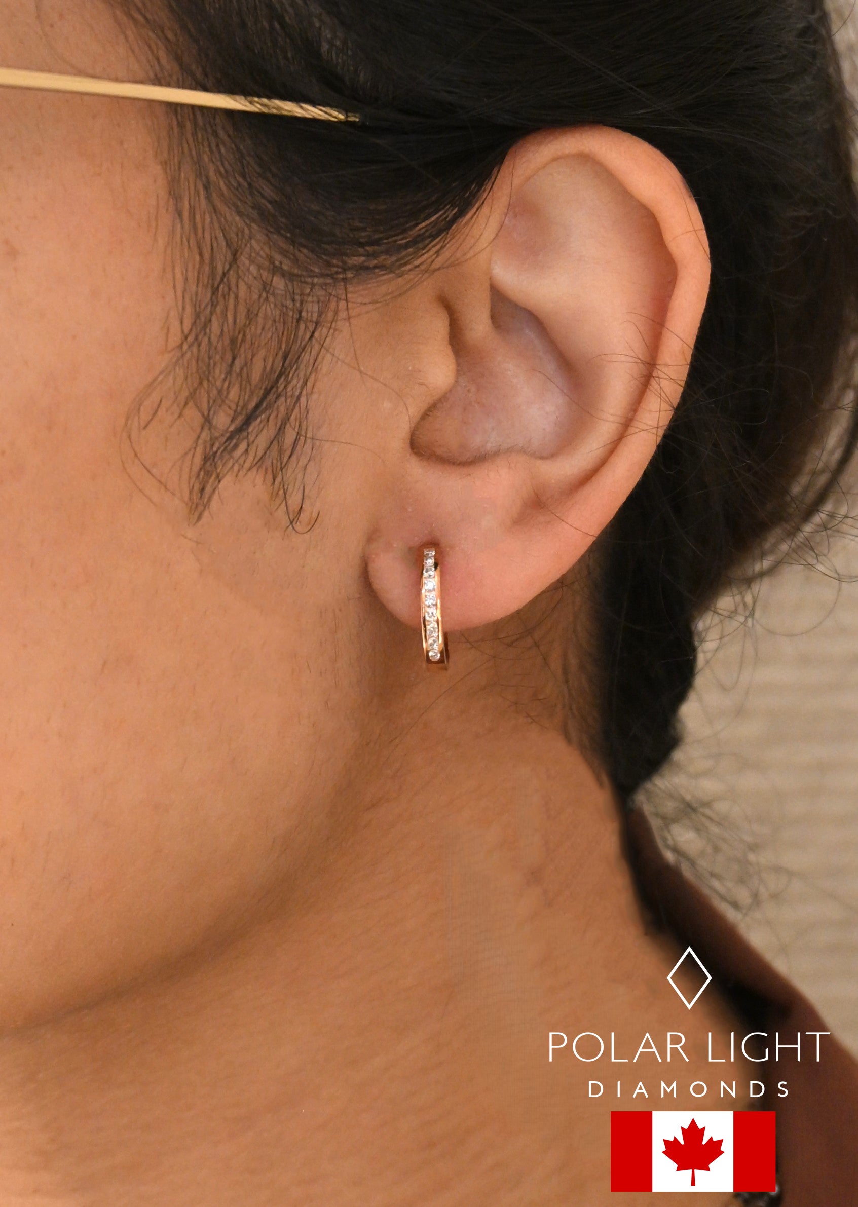 Close-up of model wearing a 10K Rose gold Canadian diamond hoop earring with 'Polar Light Diamonds' branding.