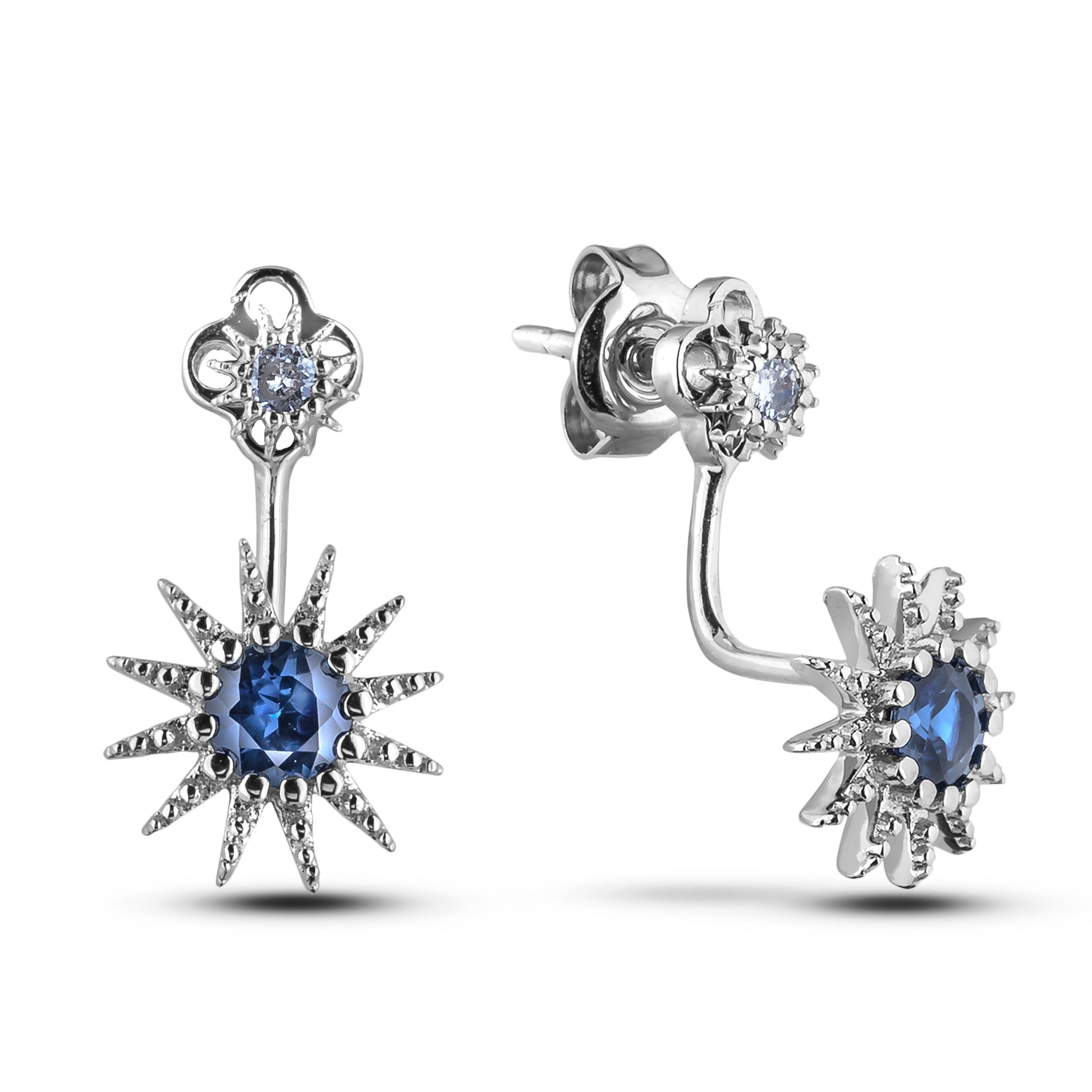 Silver earrings with blue sapphire and white diamond starburst design on a white background
