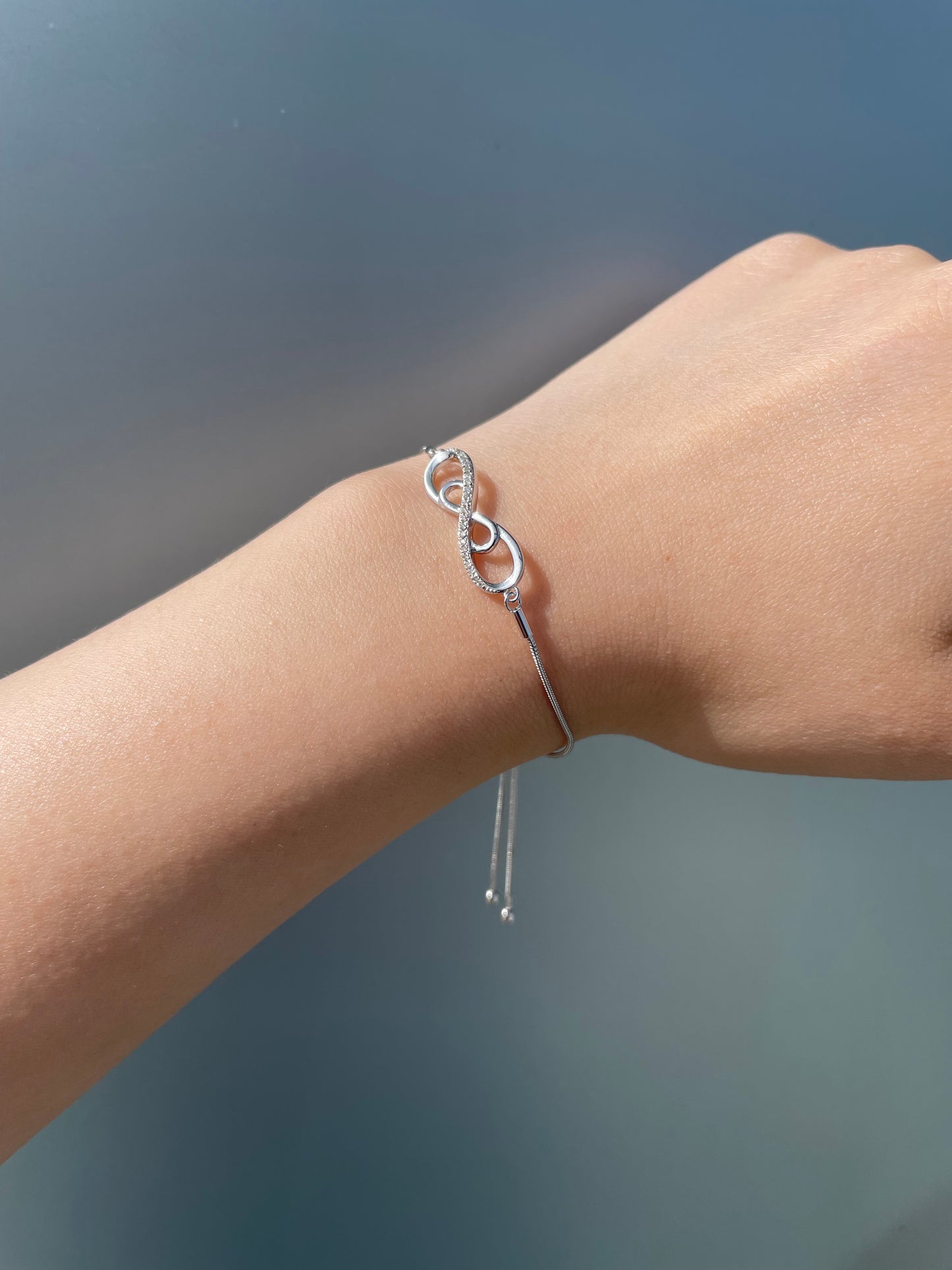 925 sterling silver bolo chain bracelet with a double infinity diamond design. Lifestyle shot on a wrist showing the sparkle of Canadian diamonds and the adjustable silver chain.