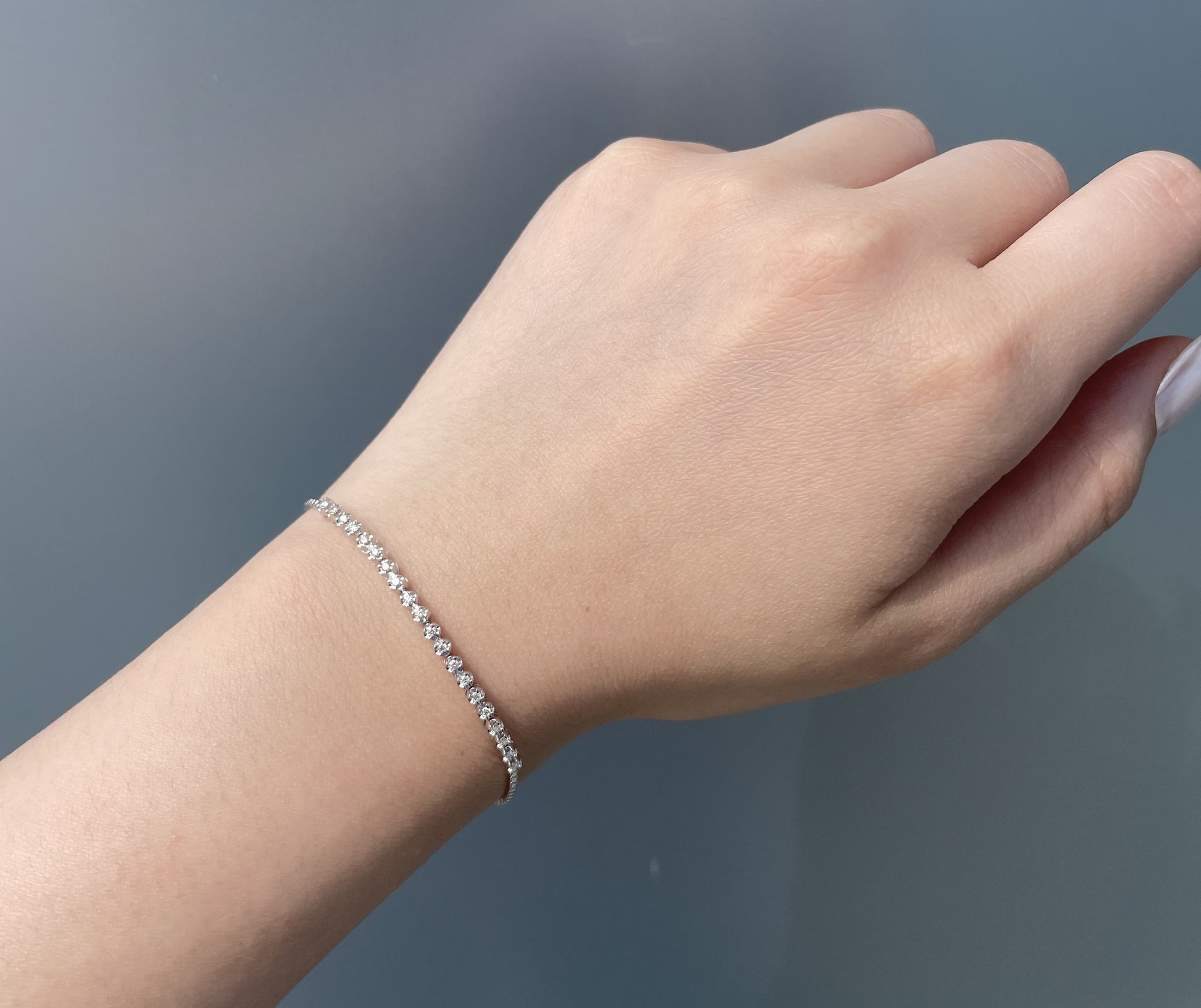 Model wearing a 925 sterling silver 0.20 Cttw Canadian diamond tennis bracelet on wrist.