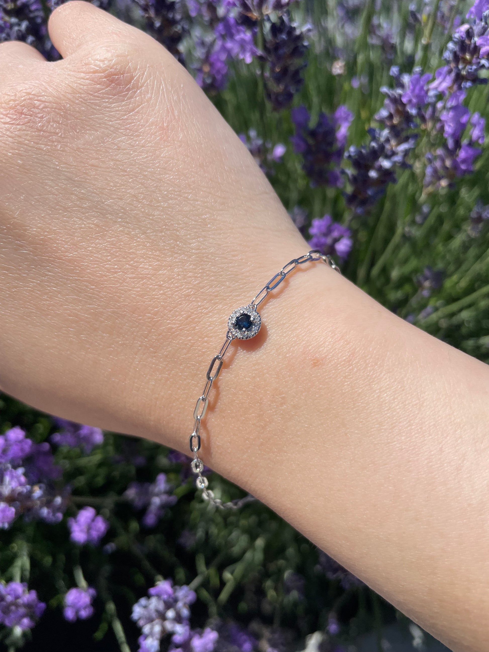 close up of model wearing 925 Sterling Silver Sapphire and Canadian Diamond Halo Paperclip Bracelet