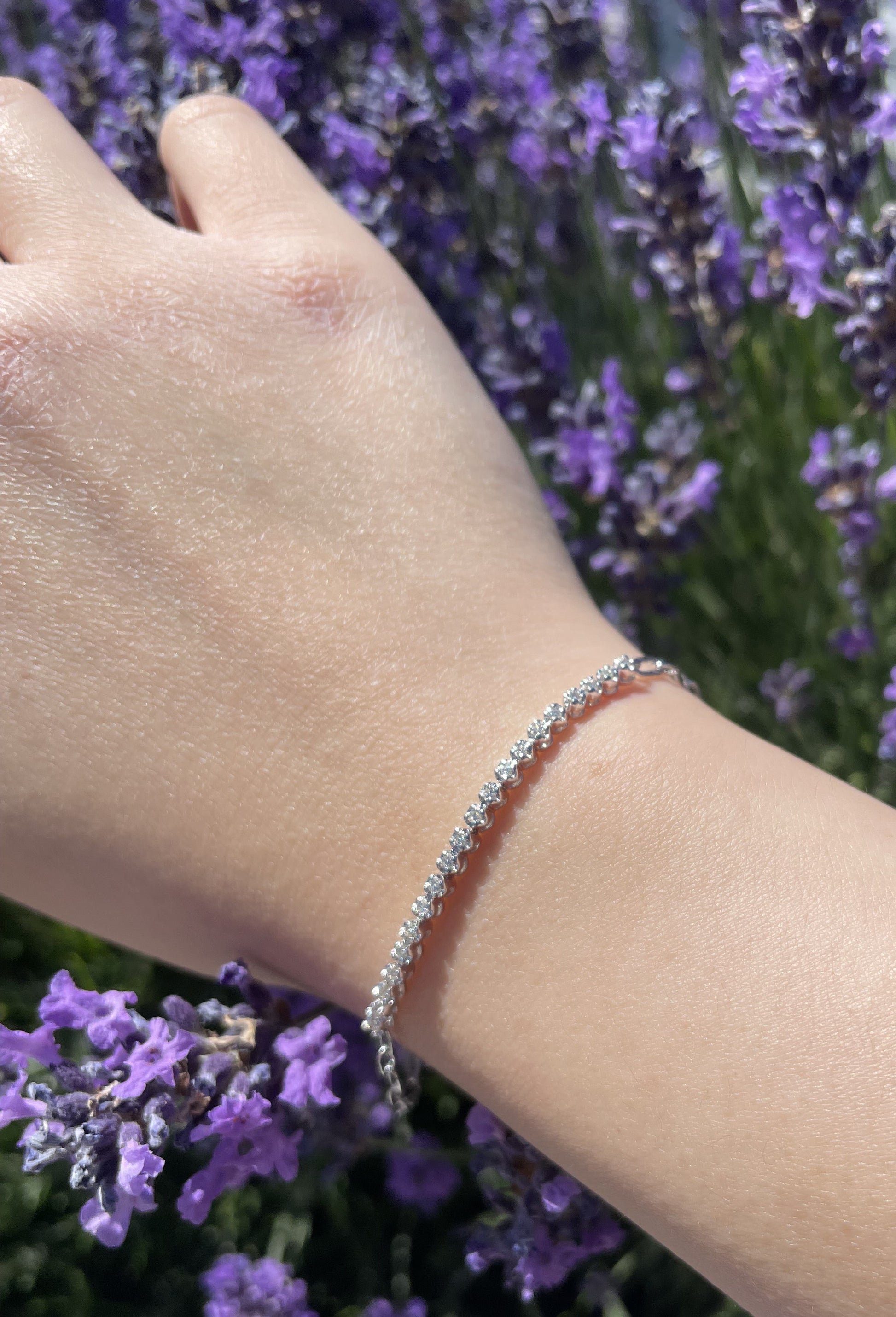 close up of 925 Sterling Silver 0.22 CTW Canadian Diamond Half Tennis Paperclip Bracelet with lavender background
