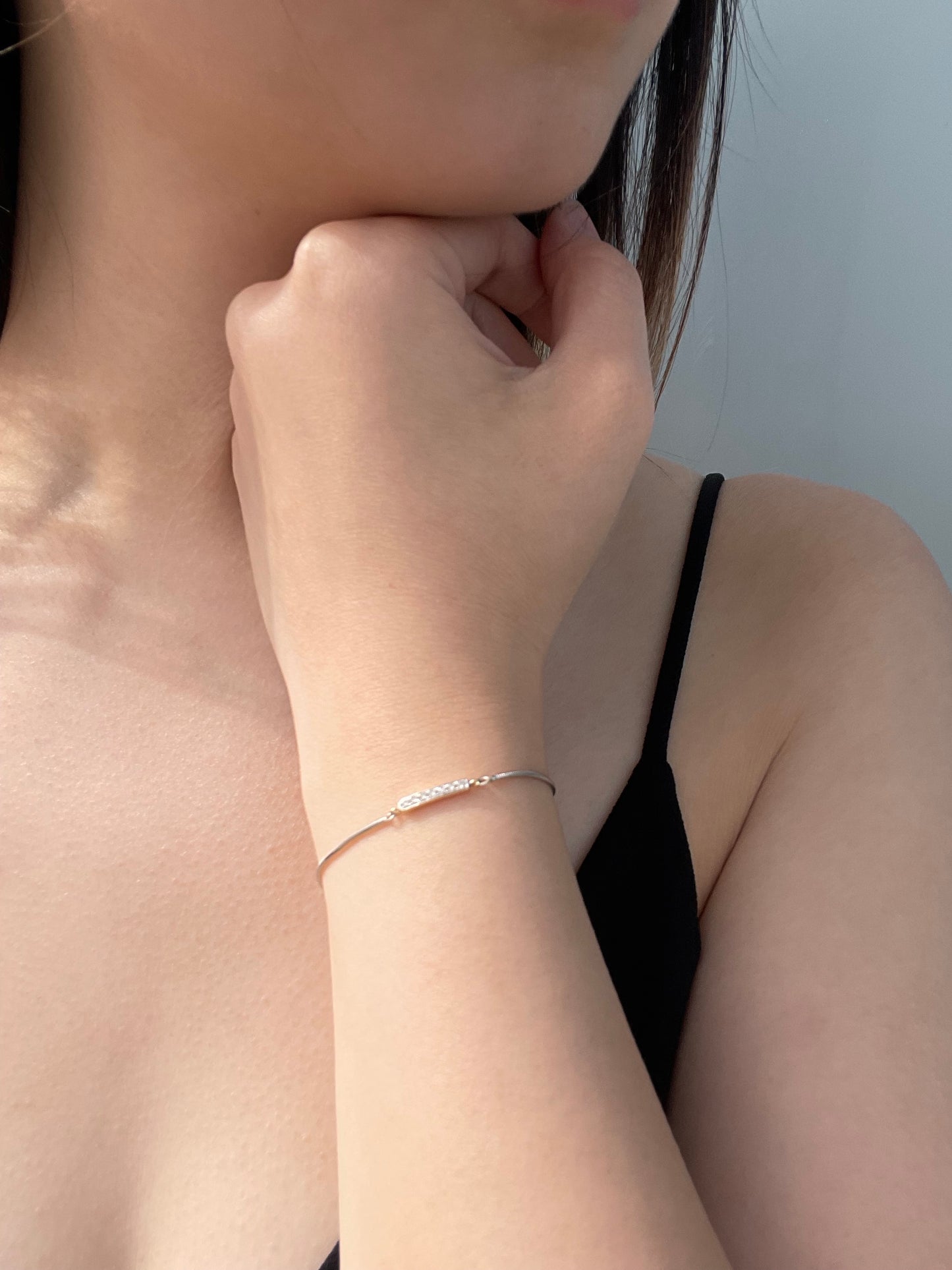 Close-up model photo showcasing a 925 sterling silver and 10K yellow gold bar adjustable bolo bracelet on a wrist, highlighting the delicate two-tone design featuring a horizontal 10k yellow gold bar set with 0.10 Cttw brilliant Canadian diamonds.