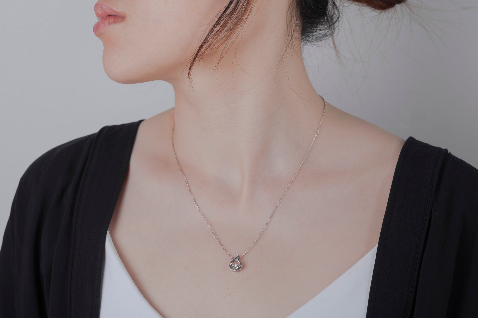 Woman wearing a sterling silver necklace with a Canadian diamond zodiac pendant, the delicate chain resting just below the collarbone, highlighting the elegant horoscope design.
