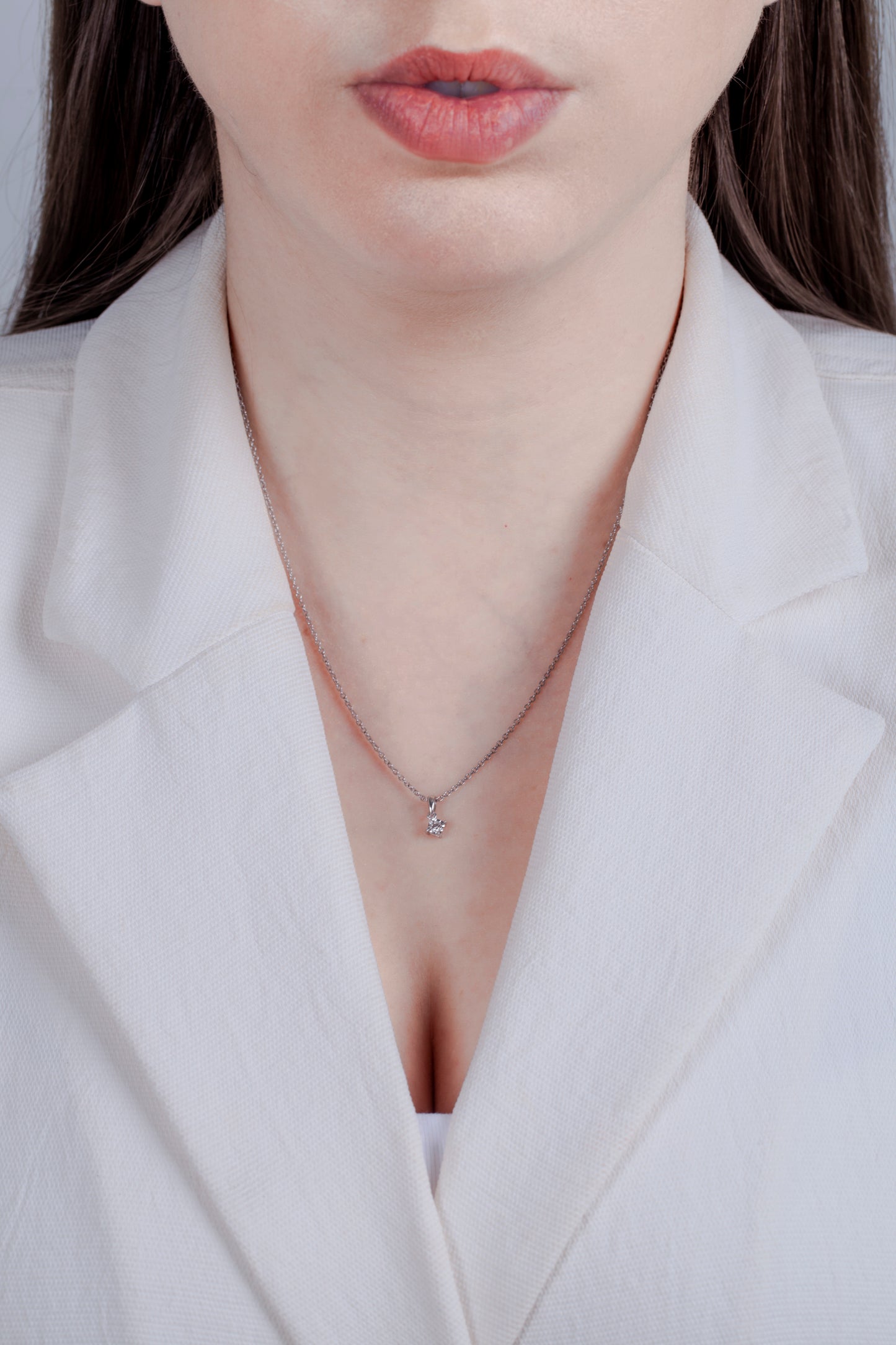 Dianty Canadian diamond pendant worn by a model in a white blazer, demonstrating a simplistic style.