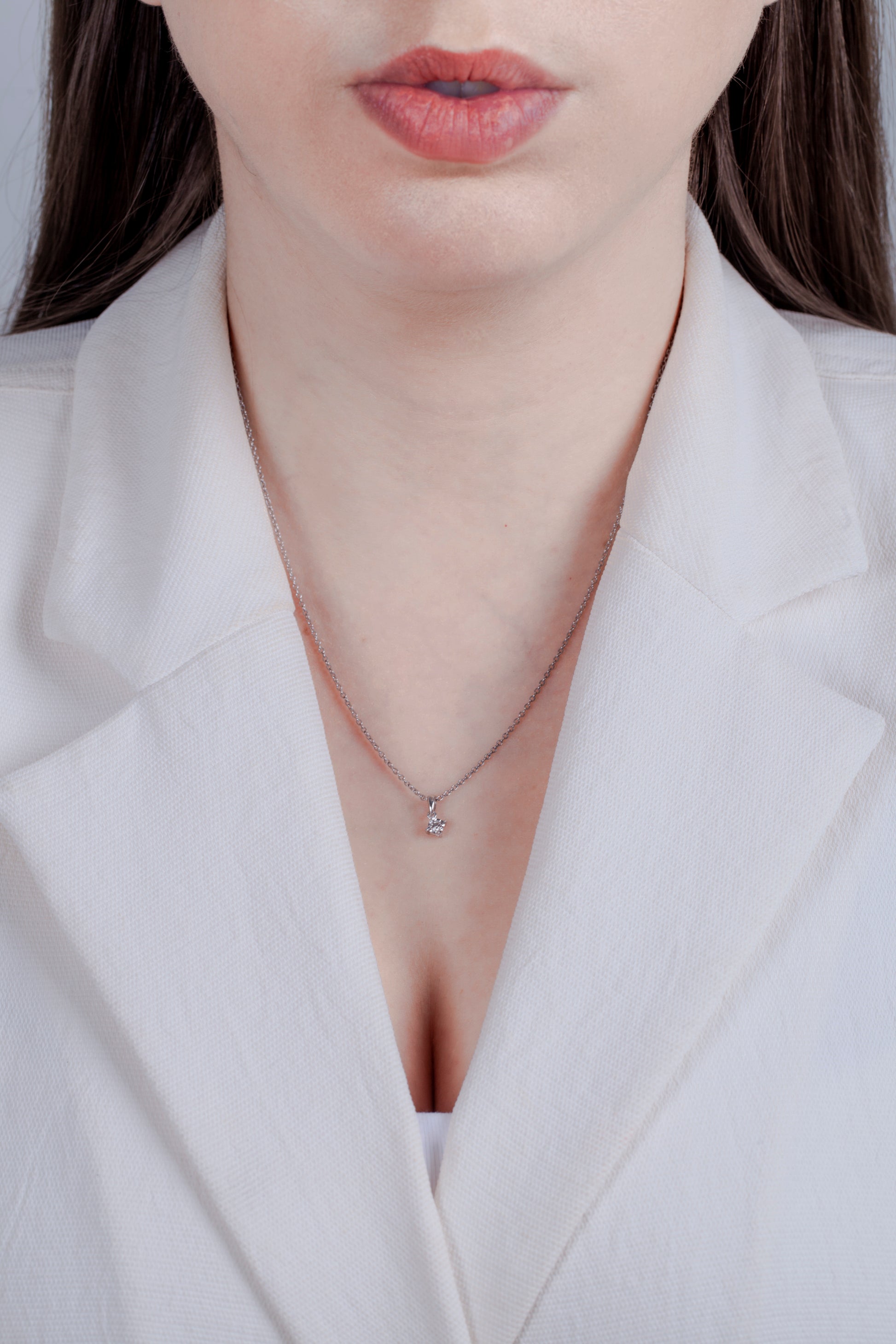 Dianty Canadian diamond pendant worn by a model in a white blazer, demonstrating a simplistic style.