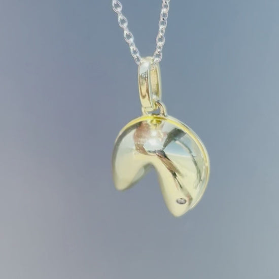 Product showcase video for the Sterling Silver 0.01 Ct Canadian Diamond Fortune Cookie Pendant & Rolo Chain Necklace. Features close-up details of the fortune cookie pendant accented with a genuine Canadian diamond (H-I color, SI2-I1 clarity), alongside an on-model view demonstrating chain length and scale.