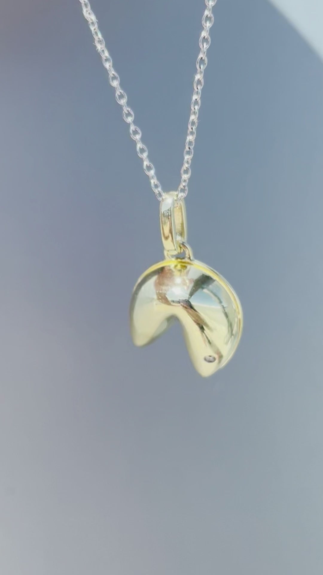 Product showcase video for the Sterling Silver 0.01 Ct Canadian Diamond Fortune Cookie Pendant & Rolo Chain Necklace. Features close-up details of the fortune cookie pendant accented with a genuine Canadian diamond (H-I color, SI2-I1 clarity), alongside an on-model view demonstrating chain length and scale.