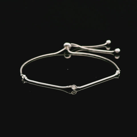 925 sterling silver adjustable bolo bracelet featuring a trilogy design with three bezel-set Canadian diamonds. The video rotates to show the sliding bolo closure and the sparkle of the diamonds.