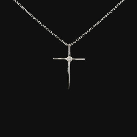 A rotating video of a slender 925 sterling silver cross pendant. The minimalist design features a single solitaire Canadian diamond at the center, which catches the light as the pendant turns to showcase its high-polish finish from all angles.