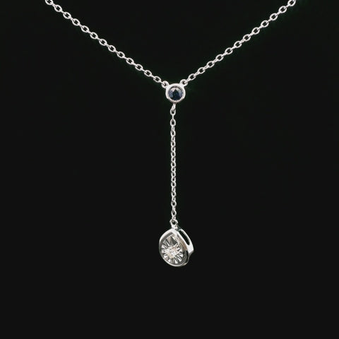 rotating video of silver dangle pendant with round sapphire and teardrop shaped diamond charm