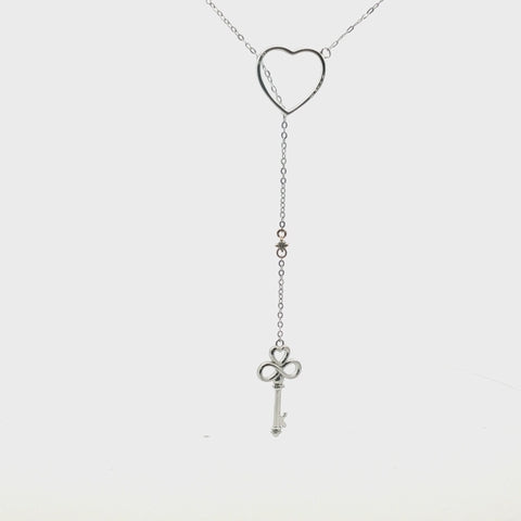Video showing a 360-degree rotating view of a two-tone 925 sterling silver and 10K yellow gold "Key to My Heart" drop pendant necklace, highlighting the sparkle of a 0.03 carat Canadian diamond from multiple angles.