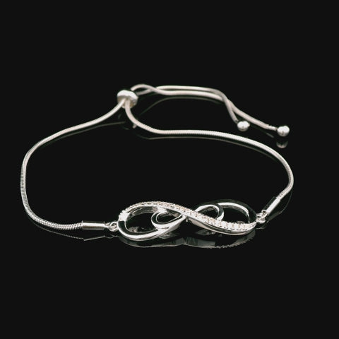 A rotating video of an adjustable 925 sterling silver bolo bracelet featuring a double infinity symbol centerpiece. The infinity loops are accented with sparkling Canadian diamonds that catch the light from every angle.