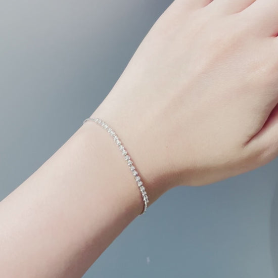 Video showing a sterling silver 0.20 Cttw Canadian diamond tennis bracelet in sunlight, featuring the sparkling diamonds and the star-detailed adjustable bolo chain and clasp.