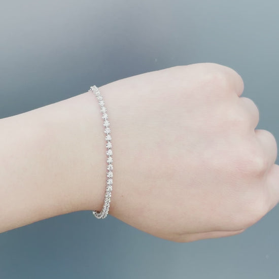 Watch a model wearing our 10K White Gold 0.76 Cttw Canadian Diamond Half Tennis Bracelet with Chain. Highlights include close-up shots of the secure clasp mechanism, precision diamond setting, and natural sunlight showcasing the brilliant diamond sparkle.