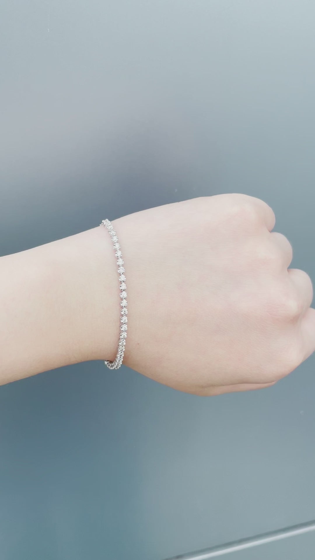 Watch a model wearing our 10K White Gold 0.76 Cttw Canadian Diamond Half Tennis Bracelet with Chain. Highlights include close-up shots of the secure clasp mechanism, precision diamond setting, and natural sunlight showcasing the brilliant diamond sparkle.