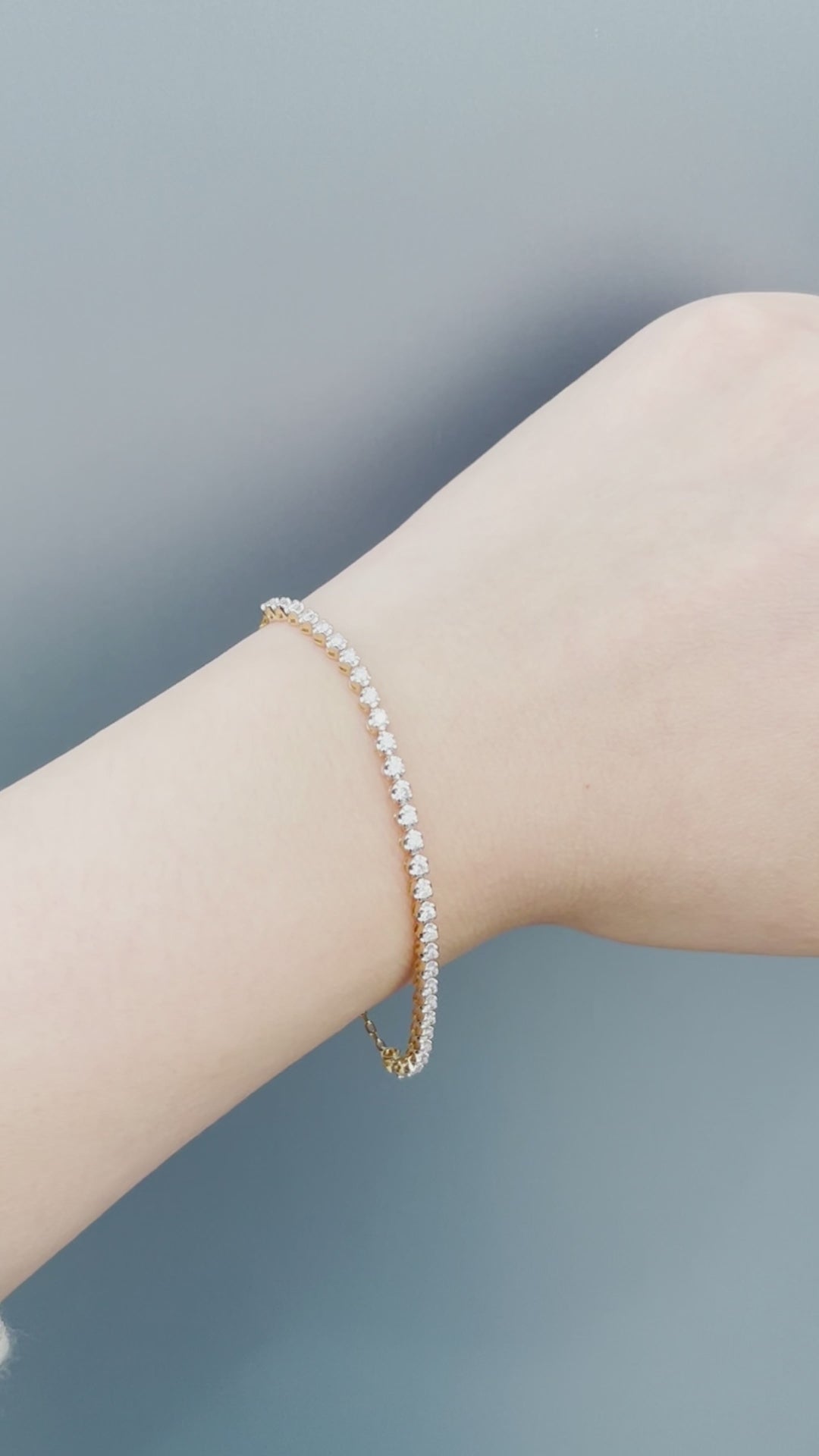 Watch a model wearing our 10K Yellow Gold 0.76 Cttw Canadian Diamond Half Tennis Bracelet with Chain. Highlights include close-up shots of the secure clasp mechanism, precision diamond setting, and natural sunlight showcasing the brilliant diamond sparkle.