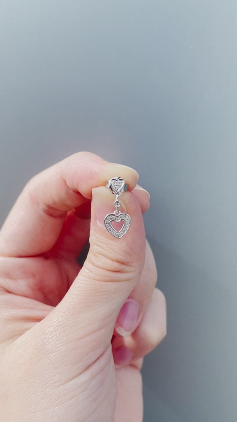 Product showcase video for the Sterling Silver 0.20 Cttw Canadian Diamond Dangle Hearts Stud Earrings. Highlights close-up details of the sparkling diamond heart dangles in natural sunlight (H-I color, SI2-I1 clarity), alongside an on-model view demonstrating fit, movement, and scale.
