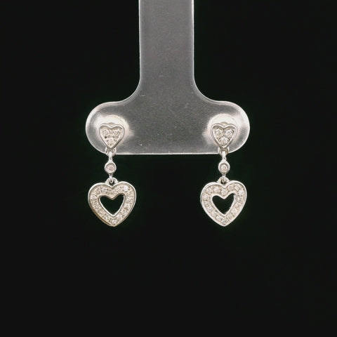 Rotation video showing all angles of sterling silver heart-shaped diamond stud earrings featuring a dangling diamond heart outline, finished with butterfly backings.