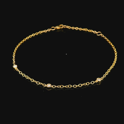 Rotating video of a 10k yellow gold trilogy bracelet showing three bezel-set diamonds and a spring ring clasp from all angles.