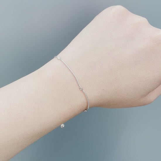 On-model showcase video of the Sterling Silver 0.06 Cttw Canadian Diamond Trilogy Adjustable Bolo Bracelet. Features close-up shots of the three natural Canadian diamonds (H-I color, SI2-I1 clarity) catching natural light, along with a view of the adjustable bolo slider mechanism.