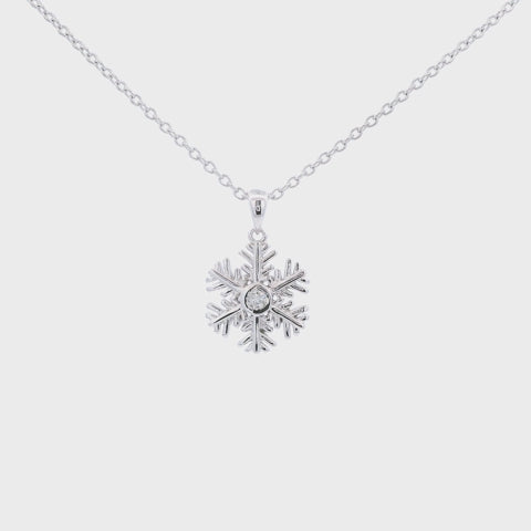 925 Sterling silver snowflake charm with a bezel set Canadian diamond at the center hanging on a rolo chain, rotating to show the design and brilliance of the pendant.