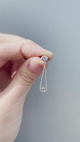 Product showcase video for the Sterling Silver 0.06 Cttw Canadian Diamond Droplet Dangle Stud Earrings. Includes close-up views highlighting the diamond droplet design (H-I color, SI2-I1 clarity), alongside an on-model video demonstrating ear placement, scale, and movement.