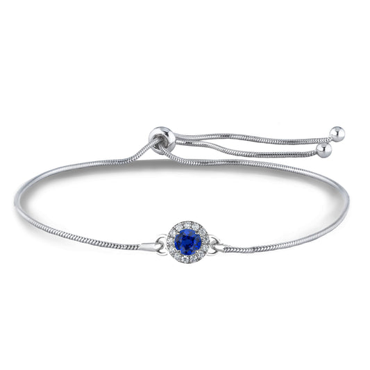 Close up of sterling silver bolo bracelet with a blue sapphire surrounded by Canadian diamonds in a halo setting on a white background